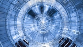 An image of the KATRIN experiment shows a metallic structure made of concentric circles and radial lines